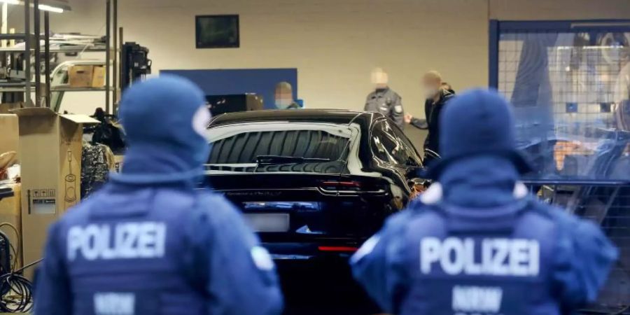 Polizisten untersuchen Räumlichkeiten in einem Gewerbegebiet in Ratingen. Foto: Roland Weihrauch/dpa
