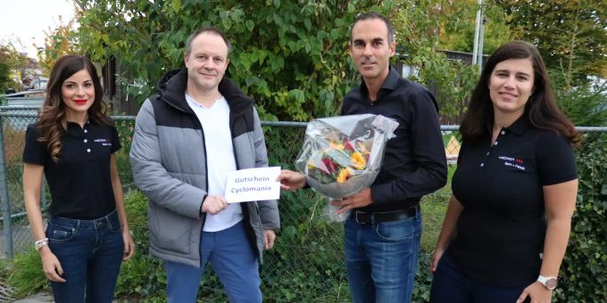 Corsin Camenisch, Geschäftsbereichsleiter Sicherheit, Sport + Kultur, (rechts) übergibt Roger Hutter den Hauptpreis der Velo-Challenge Cyclomania Stadt Wetzikon. Mit dabei bei der Preisübergabe sind Krizia Farmakis, Sachbearbeiterin und Sportkoordinatorin, (links) und Angelika Binder, Assistentin Leiter Sport + Freizeit.