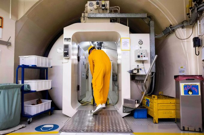 02.12.2021, Schleswig-Holstein, Brokdorf: Ein Mitarbeiter des Kernkraftwerk Brokdorf zieht einen Materialwagen aus der Hauptschleuse zum Reaktorgebäude. Nach knapp 35 Jahren Betriebszeit wird das Atomkraftwerk von Betreiber Preussen Elektra abgeschaltet. AKW Brokdorf wird stillgelegt