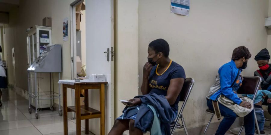 Menschen warten in der Hillbrow Clinic in Johannisburg auf eine Impfung gegen das Coronavirus. Nach Angaben der Weltgesundheitsorganisation WHO vom Donnerstag scheint eine Infektion mit der neuen Coronavirus-Variante Omikron in Südafrika nicht so häufig zu schwereren Krankheitsverläufen zu führen. Foto: Shiraaz Mohamed/AP/dpa