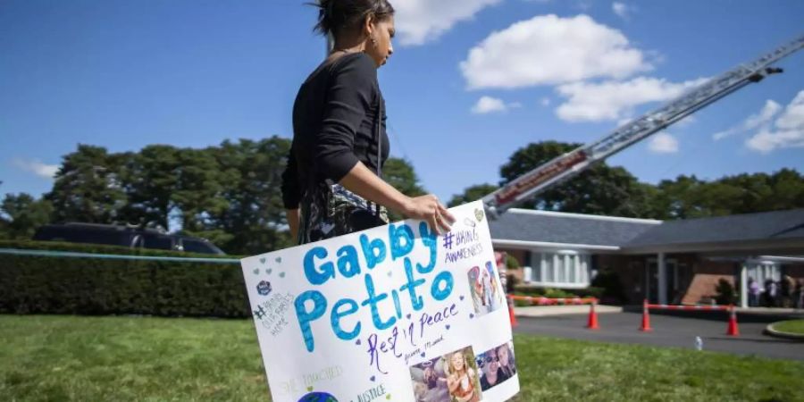 Eine Frau trägt während der Trauerfeier am 26. September ein Plakat zu Ehren Petitos. Foto: Eduardo Munoz Avarez/AP/dpa