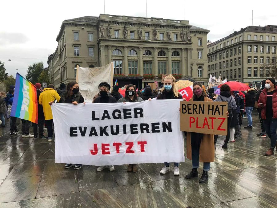 Demonstranten halten an der heutigen Demo auf dem Bundesplatz ihre Plakate in die Kamera.