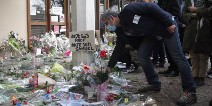 Ein Mann legt Blumen für den getöteten Geschichtslehrer nahe Paris nieder. Paris