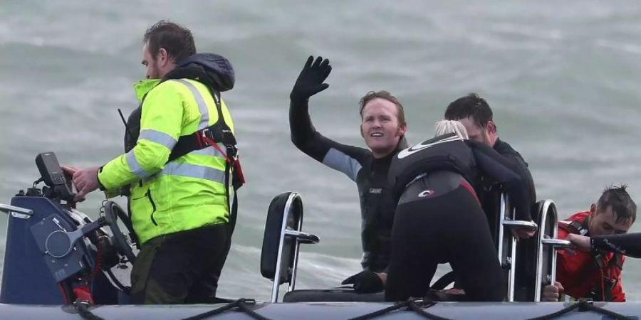John Bream, ehemaliger Fallschirmspringer aus Grossbritannien, winkt aus einem Boot, das ihn nach seinem Sprung aus etwa 40 Metern Höhe ins Meer geborgen hat. Foto: Andrew Matthews/PA Wire/dpa
