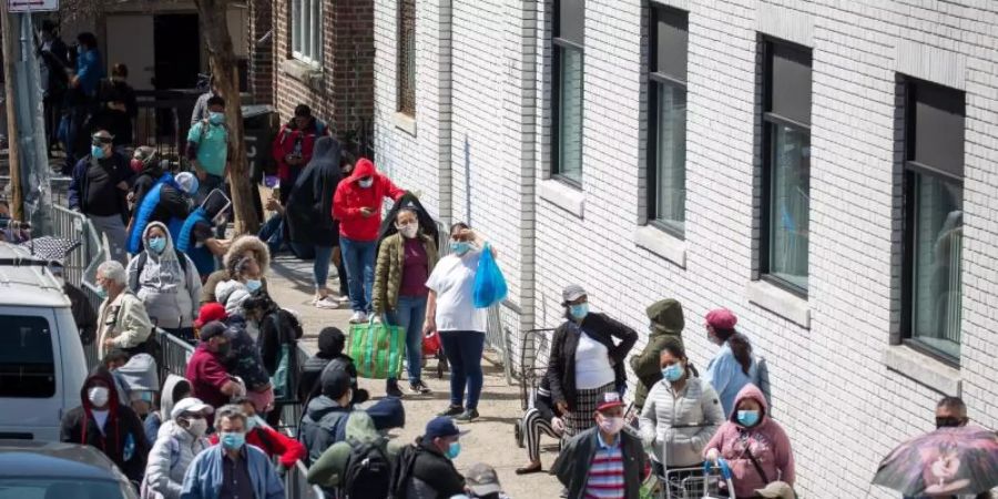 Menschen stehen Schlange vor einer Lebensmittelausgabe für Bedürftige im New Yorker Stadtteil Brooklyn. Seit Mitte März haben in den USA Millionen Menschen zumindest zeitweise ihren Job verloren. Foto: Michael Nagle/XinHua/dpa