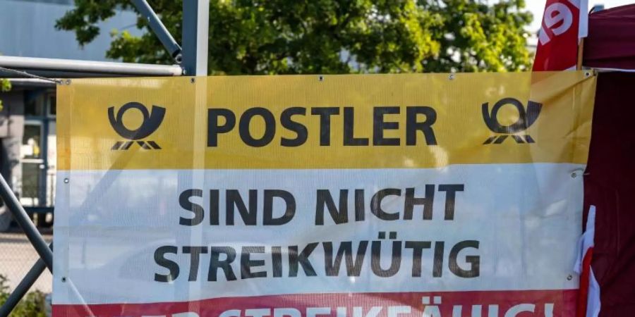 Ein Plakat vor einem Briefzentrum der Post im bayerischen Straubing. Foto: Armin Weigel/dpa