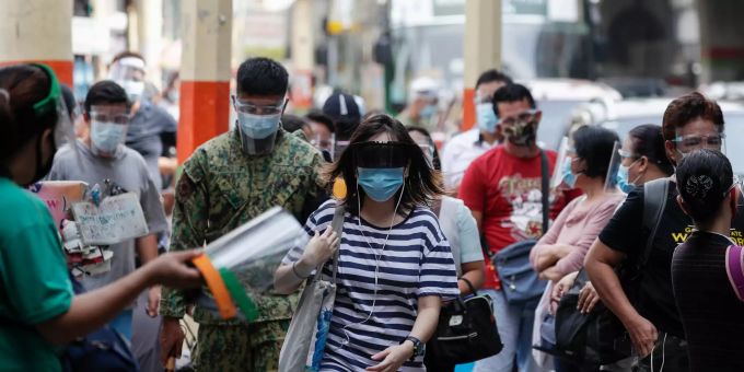 Passanten tragen Schutzmasken auf der Strasse in den Philippinen. Coronavirus - Philippinen
