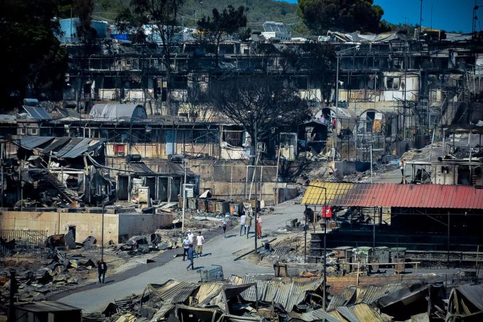 Bewohnerinnen und Bewohner gehen zwischen beschädigten Unterkünften im Flüchtlingslager Moria, nachdem dort mehrere Feuer ausgebrochen waren und das Lager nahezu vollständig zerstört haben. Foto: Eurokinissi Brand in Flüchtlingslager Moria auf Lesbos