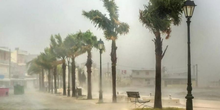 Meerwasser überflutet eine Strasse im Hafen von Argostoli. Der schwere Herbststurm «Ianos» mit den Merkmalen eines Hurrikans bewegt sich langsam entlang der Küste der griechischen Halbinsel Peloponnes. Foto: Nikiforos Stamenis/AP/dpa