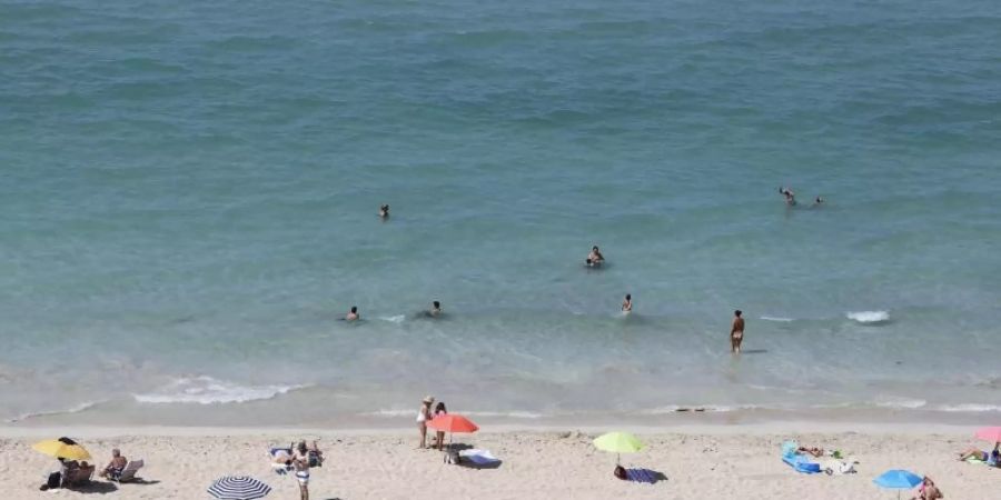 Badegäste am Strand von Arenal auf Mallorca. Deutsche Tourismuskonzerne kritisieren die Reisewarnung des Auswärtigen Amtes für die spanische Insel. Foto: Clara Margais/dpa