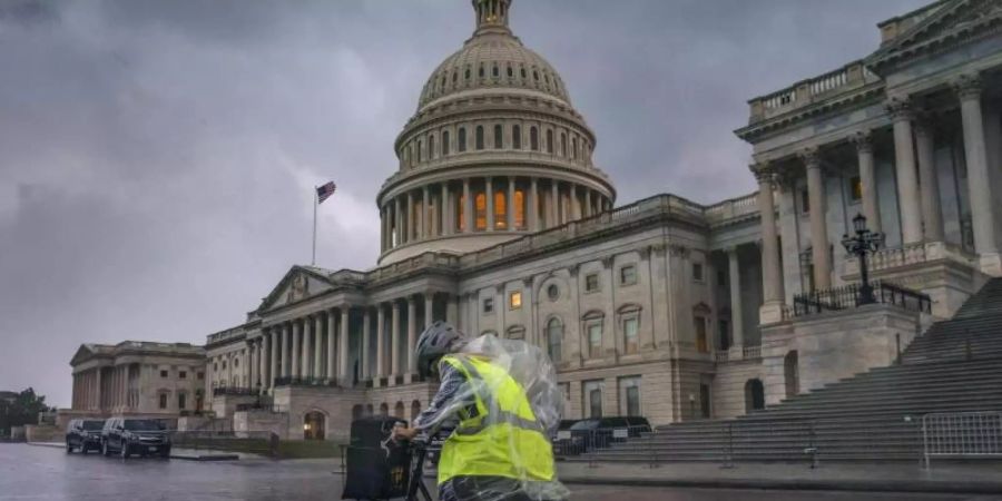 Eine Fahrradfahrerin kämpft auf dem Capitol Hill in Washington gegen Wind und starken Regen. Foto: J. Scott Applewhite/AP/dpa