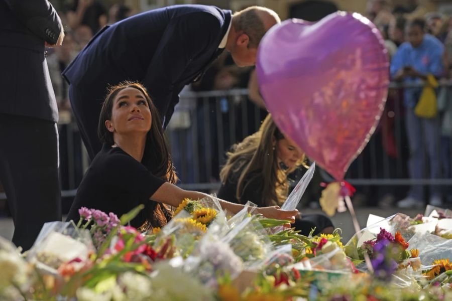 Meghan Markle schaut sich die Blumen-Tribute für die Queen an.