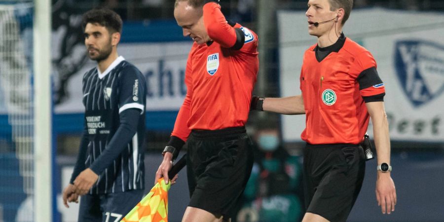 Das Schiedsrichtergespann verlässt das Spielfeld, nachdem Schiedsrichterassistent Christian Gittelmann (2.v.r.) einen Becher an den Kopf bekommen hatte.