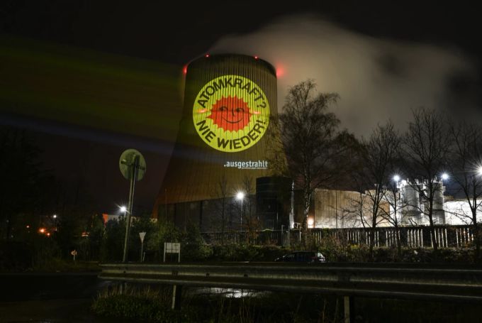 Aktivisten der Anti-Atom-Bewegung projizieren eine große Anti-Atom-Sonne auf den Kühlturm des Atomkraftwerkes Emsland. Atomkraftwerke Atomausstieg in Deutschland
