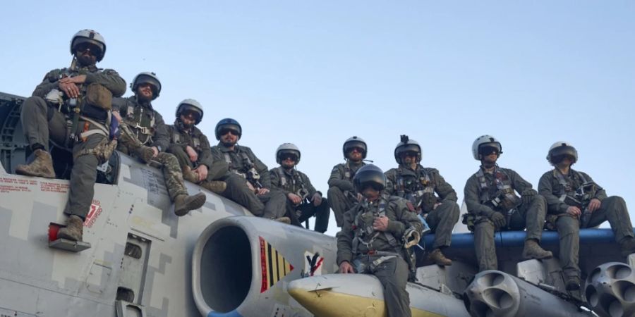 Piloten der ukrainischen Luftwaffe sitzen auf einem Bodenkampfflugzeug in der Ostukraine. Foto: LIBKOS/AP/dpa