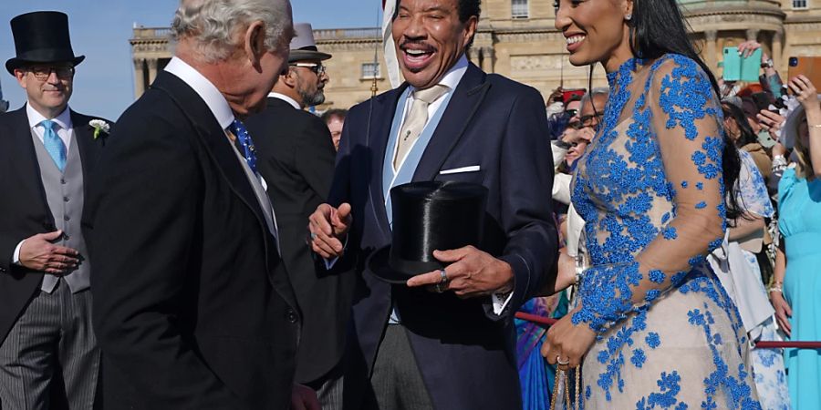 König Charles III. spricht während einer Gartenparty im Buckingham Palace, die anlässlich der Krönung von König Charles III. und der Königsgemahlin stattfindet, mit Lionel Richie und Lisa Parigi. Foto: Yui Mok/PA Wire/dpa