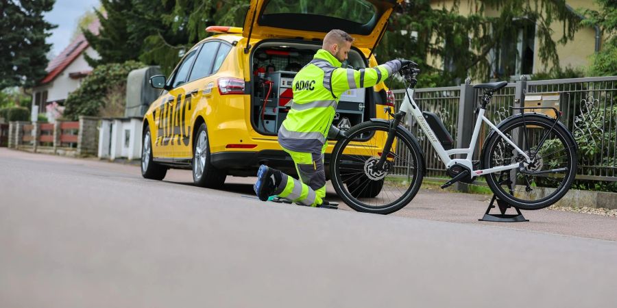 ADAC-Pannenhelfer Maik Musculus leistet Pannenhilfe an einem E-Bike.