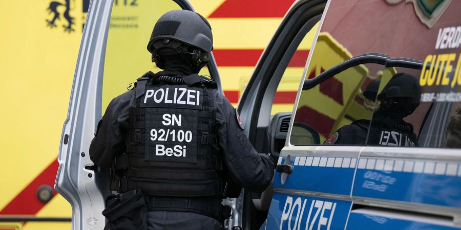 Eine Beamtin steigt im Dresdner Stadtteil Leipziger Vorstadt in ein Polizeiauto.