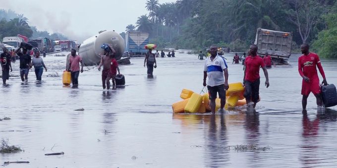 Menschen im nigerianischen Bayelsa waten durch überflutete Strassen. überflutete Strassen in Bayelsa