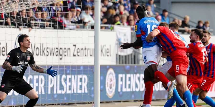 Kiels Kwasi Wriedt (M) kommt gegen Heidenheims Torwart Kevin Müller (l) zum Kopfball.