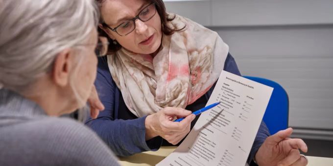 Frau erklärt Seniorin etwas