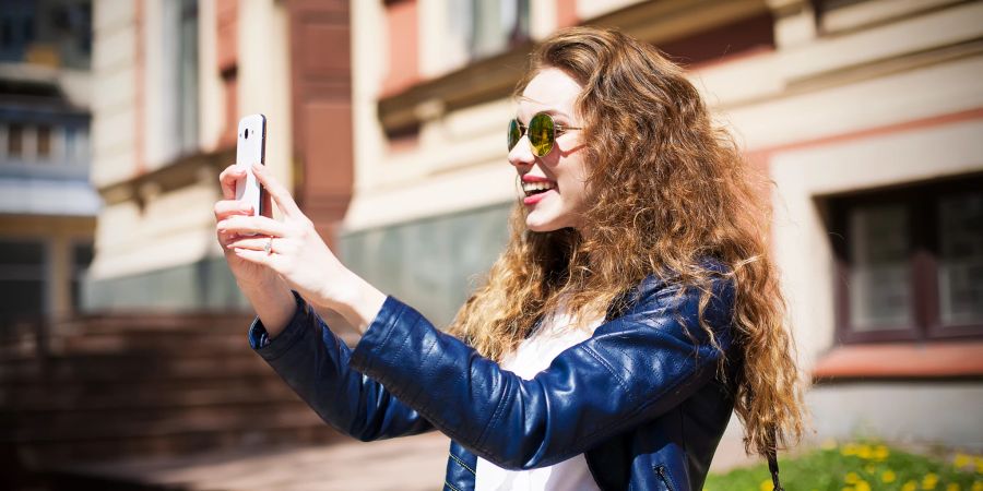 Frau schießt Bild mit Smartphone