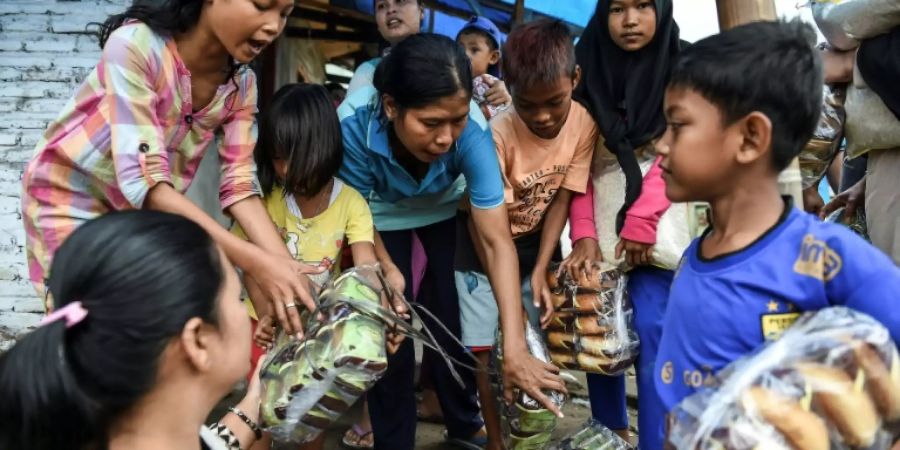 Kinder in Indonesien bekommen nach Tsunami Essensspenden