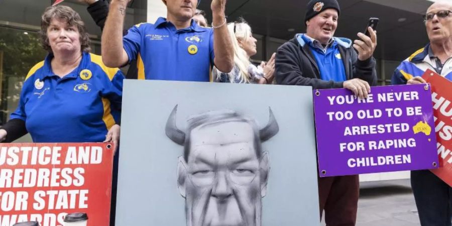 Demonstranten stehen vor dem County Court, nachdem das Urteil gegen Kardinal Pell verkündet wurde. Der ehemalige Finanzchef des Vatikans ist wegen sexuellen Missbrauchs von Minderjährigen zu sechs Jahren Haft verurteilt worden. Foto: Daniel Pockett/AAP