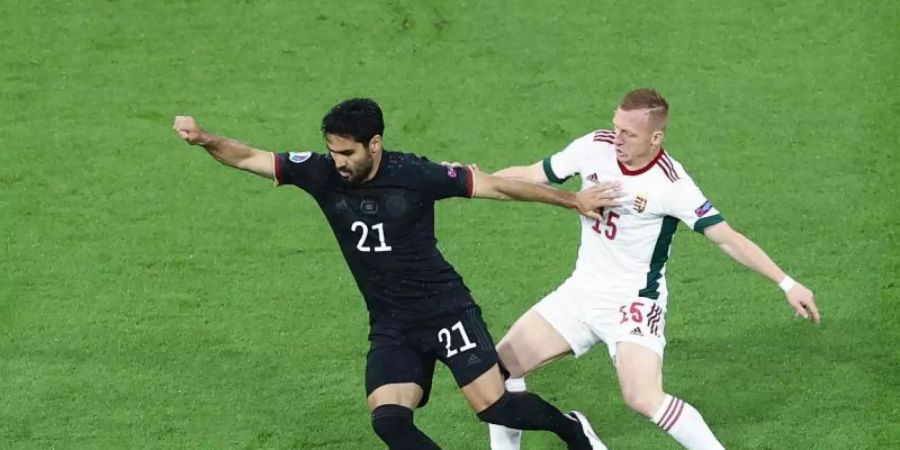 Arbeitete bis zu seiner Auswechslung viel, aber glücklos: Ilkay Gündogan (l) gegen Ungarns Laszlo Kleinheisler in Aktion. Foto: Christian Charisius/dpa