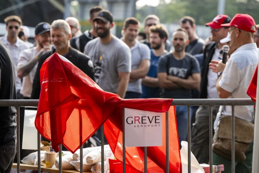 Gewerkschaftler und Mitarbeitende versammeln sich vor dem Flughafen Genf zu einem Streik.