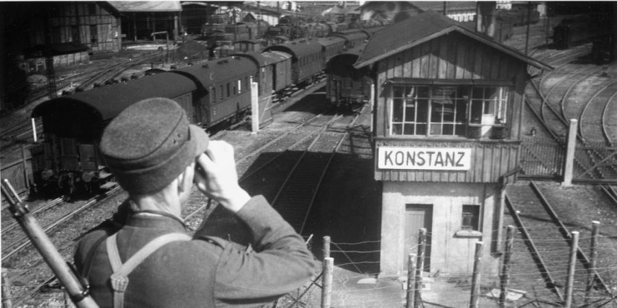 Ein Schweizer Soldat beobachtet durch sein Fernglas den Bahnhof Konstanz D, aufgenommen gegen Ende des Zweiten Weltkriegs im April 1945. (Archivbild)