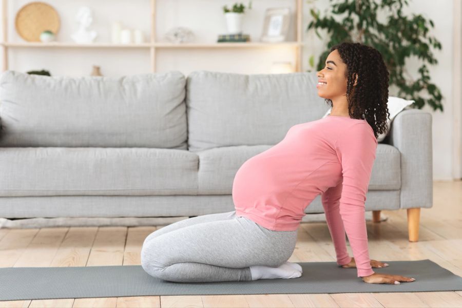 schwangere yoga auf grauer matte