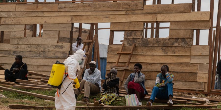 ARCHIV - Ein Mitarbeiter des Gesundheitswesens desinfiziert den Bereich um eine im Bau befindliche Behandlungsstation im Allgemeinen Krankenhaus in Bunia. Foto: Moses Sawasawa/AP/dpa