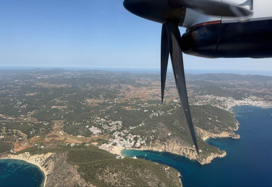 Türkisblaues Wasser und malerische Buchten beim Anflug auf Ibiza.