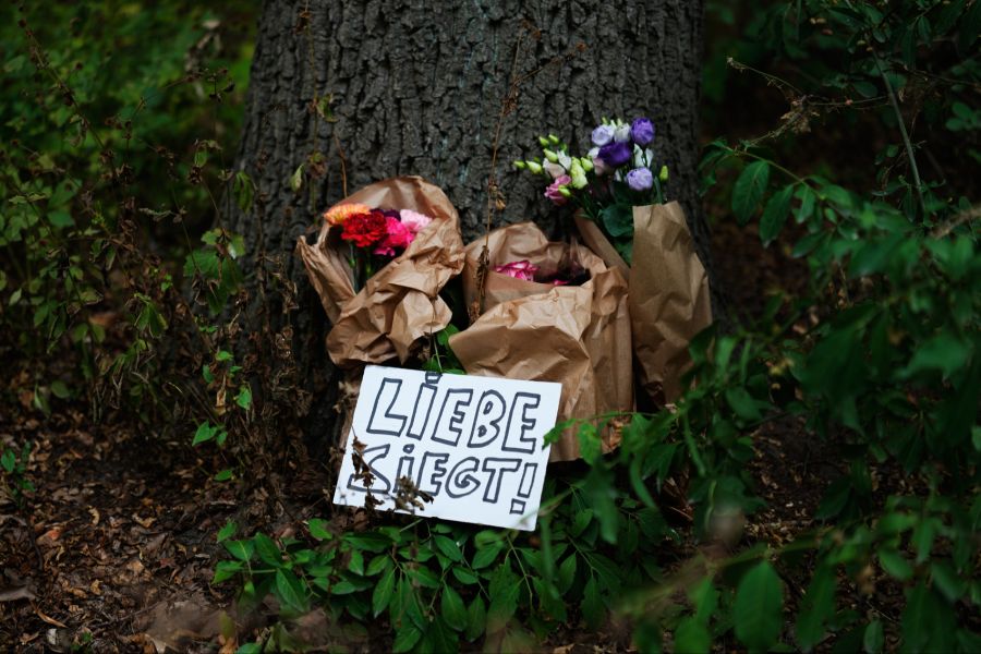 Es werden Blumen und Schilder niedergelegt.