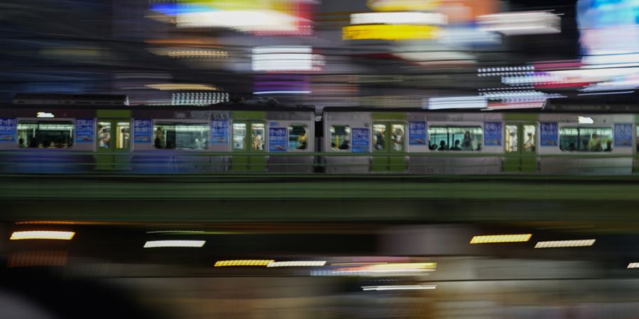 ARCHIV - Ein Zug fährt durch das Vergnügungsviertel Shinjuku. Foto: Kiichiro Sato/AP/dpa