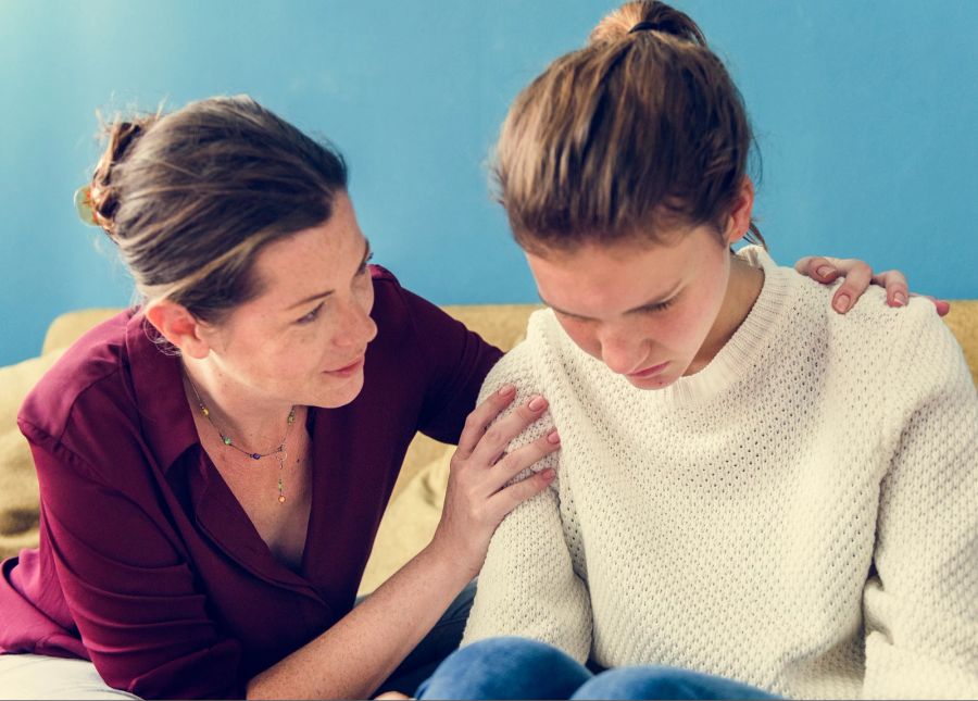 Mutter tröstet Teenager-Tochter.