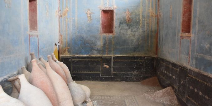 Ein Raum mit blauen Wänden und gemalten weiblichen Figuren ist in Pompeji freigelegt worden. Pompeji