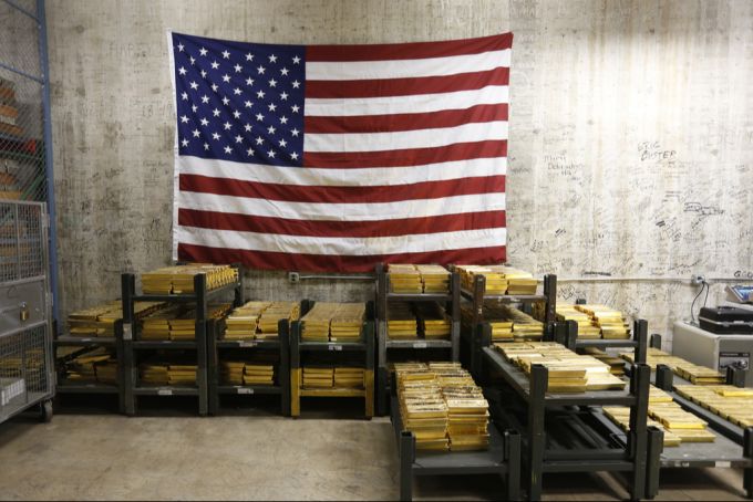 Aufgrund möglicher Zölle verstärkte sich der US-Goldimport. (Symbolbild) USA Flagge Goldbarren Zölle
