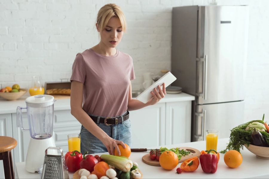 junge frau mit viel obst in der küche