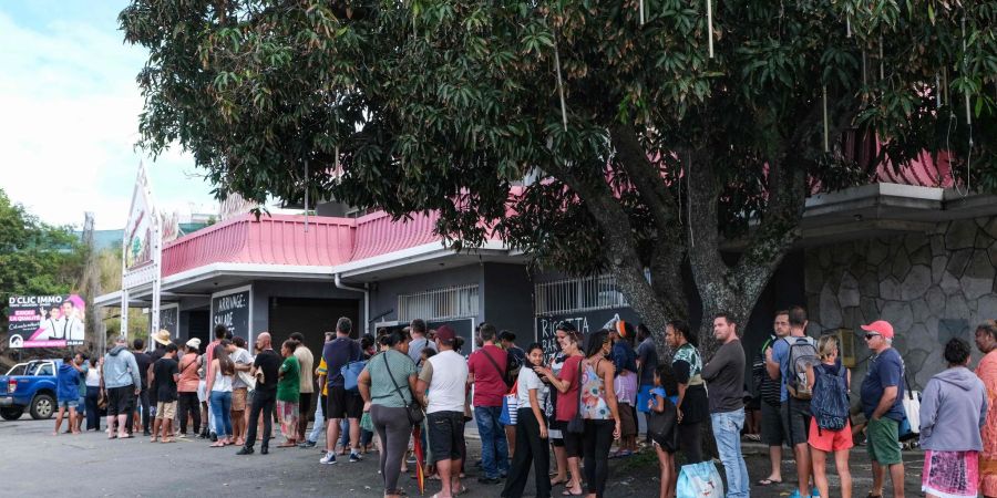 Ein lange Schlange vor einem 
Gemischtwarenladen in Nouméa.