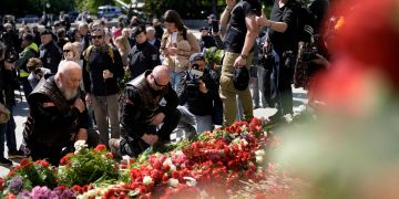 «Nachtwölfe» knien vor Blumen.