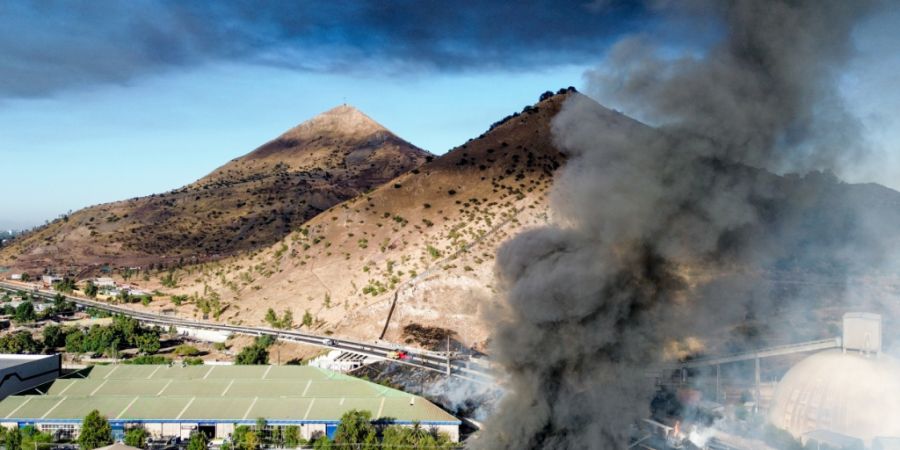 Rauch steigt in den Himmel, nachdem ein mit Flüssiggas beladener Tanklaster in einem Industriegebiet nahe Santiago de Chile umkippte und explodierte. Foto: Hans Scott/Agencia Uno/dpa