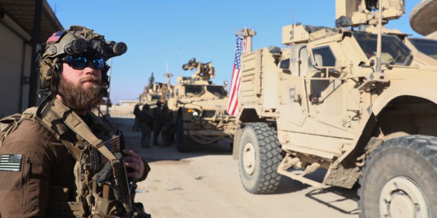 ARCHIV - Ein amerikanischer Soldat der US-geführten Koalition gegen die Gruppe Islamischer Staat steht während eines Treffens mit den von den USA unterstützten Syrischen Demokratisch...