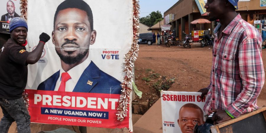 ARCHIV - Ein Anhänger des oppositionellen ugandischen Präsidentschaftskandidaten Robert Kyagulanyi, bekannt als Bobi Wine, hält ein Wahlkampfplakat fest. Foto: Hajarah Nalwadda/AP/dpa