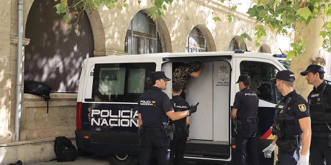 Polizisten stehen um den Transport, in dem die Verdächtigen zum Termin mit dem Haftrichter auf der Balearischen Insel gebracht wurden. Männer in Polizeiauto