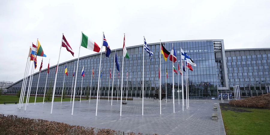 Die Flaggen der NATO-Mitgliedsstaaten flattern im Wind vor dem NATO-Hauptquartier. Die Nato-Aussenminister kommen in Brüssel zusammen, um über Pläne für eine besser vorhersehbare, längerfristige Unterstützung der Ukraine zu beraten. Foto: Virginia Mayo/AP/dpa