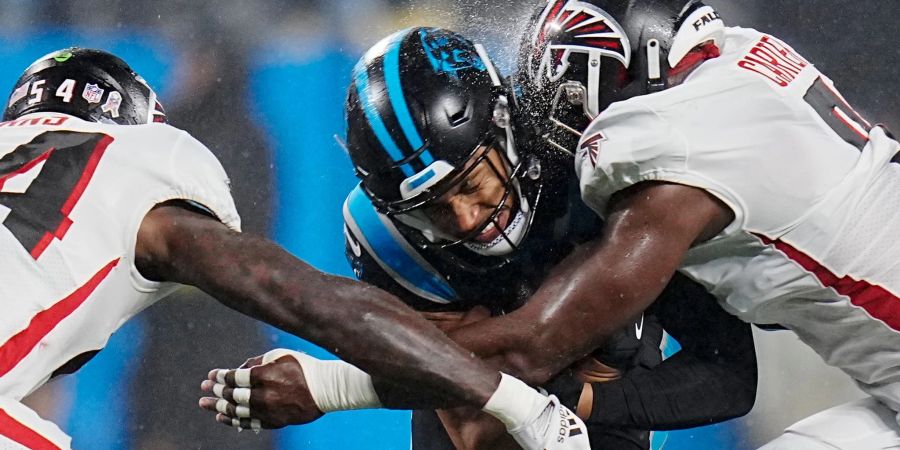 Carolina Panthers Chuba Hubbard (M) wird von Atlanta Falcons Rashaan Evans (l) und Lorenzo Carter angegriffen.