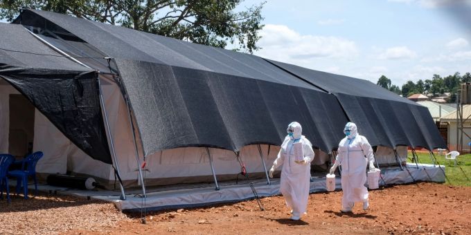 Zwei Ärzte in Schutzanzügen gehen zum Ebola-Isolationsbereich des Mubende Regional Referral Hospital. Im ostafrikanischen Uganda ist die Zahl neuer Infektionen mit dem tödlichen Ebola-Virus über das Wochenende rasant angestiegen. Uganda Impfstoffe