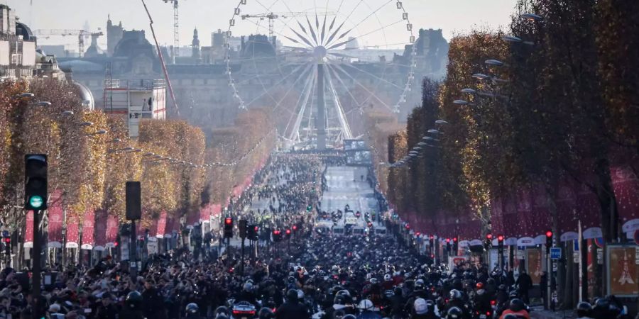 Motorradfahrer fahren auf der Champs Elysées hinter dem Leichenwagen mit dem Sarg des verstorbenen französischen Musikers Johnny Hallyday.